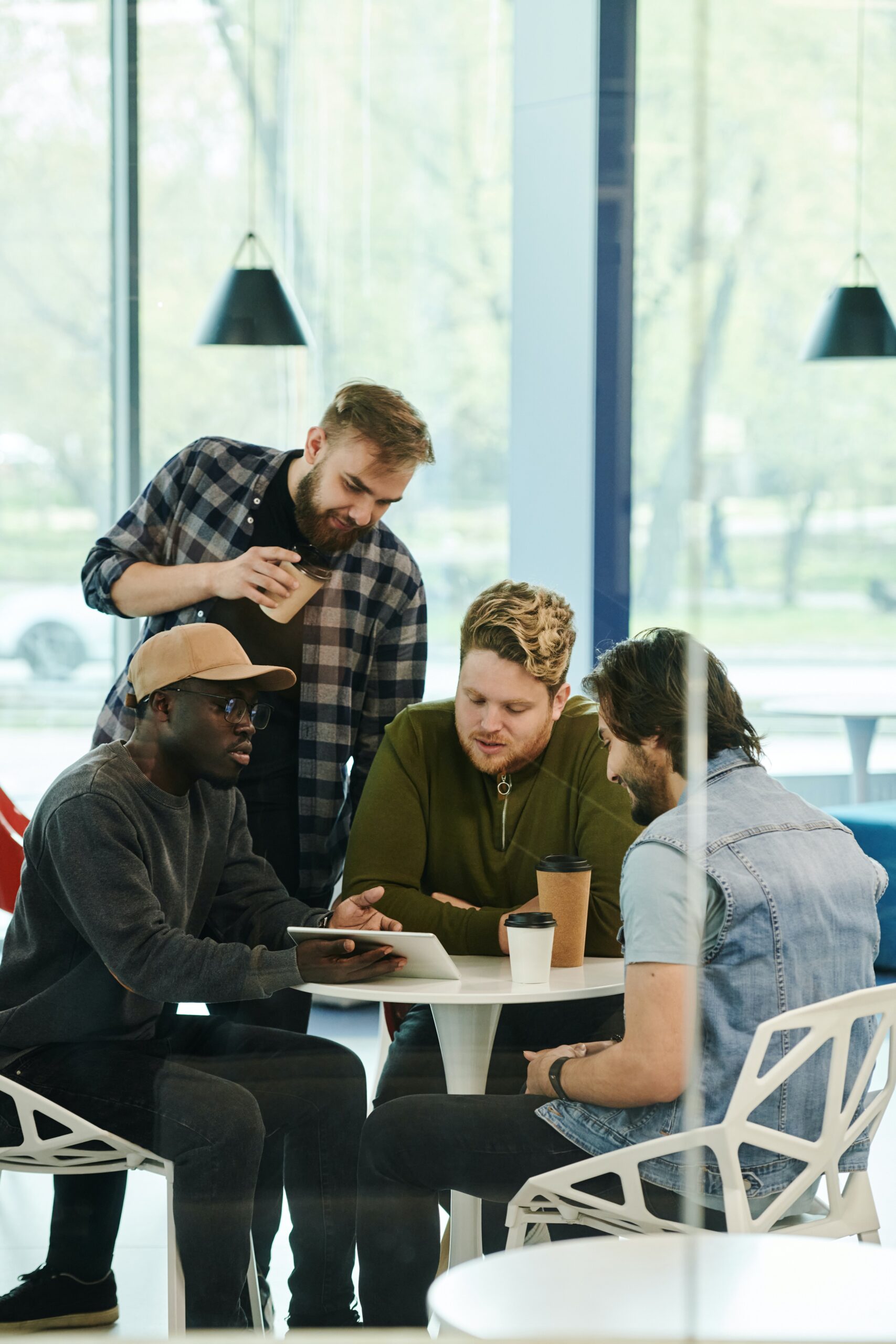 people sitting around a table looking at ipad talking