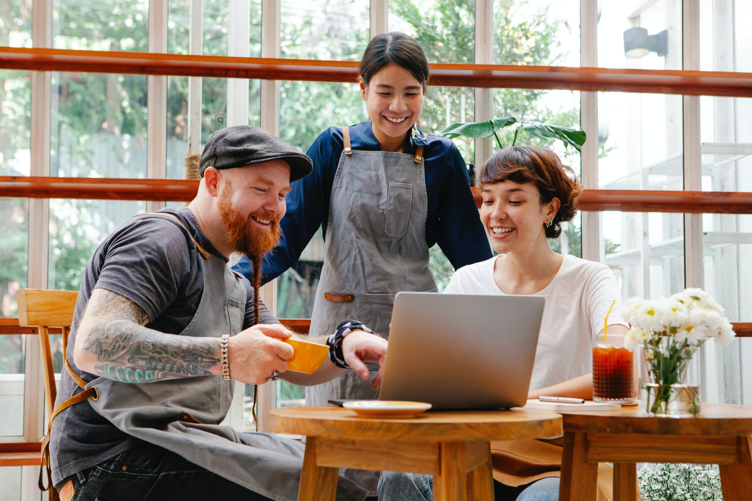 3 people sitting in front of computer smiling