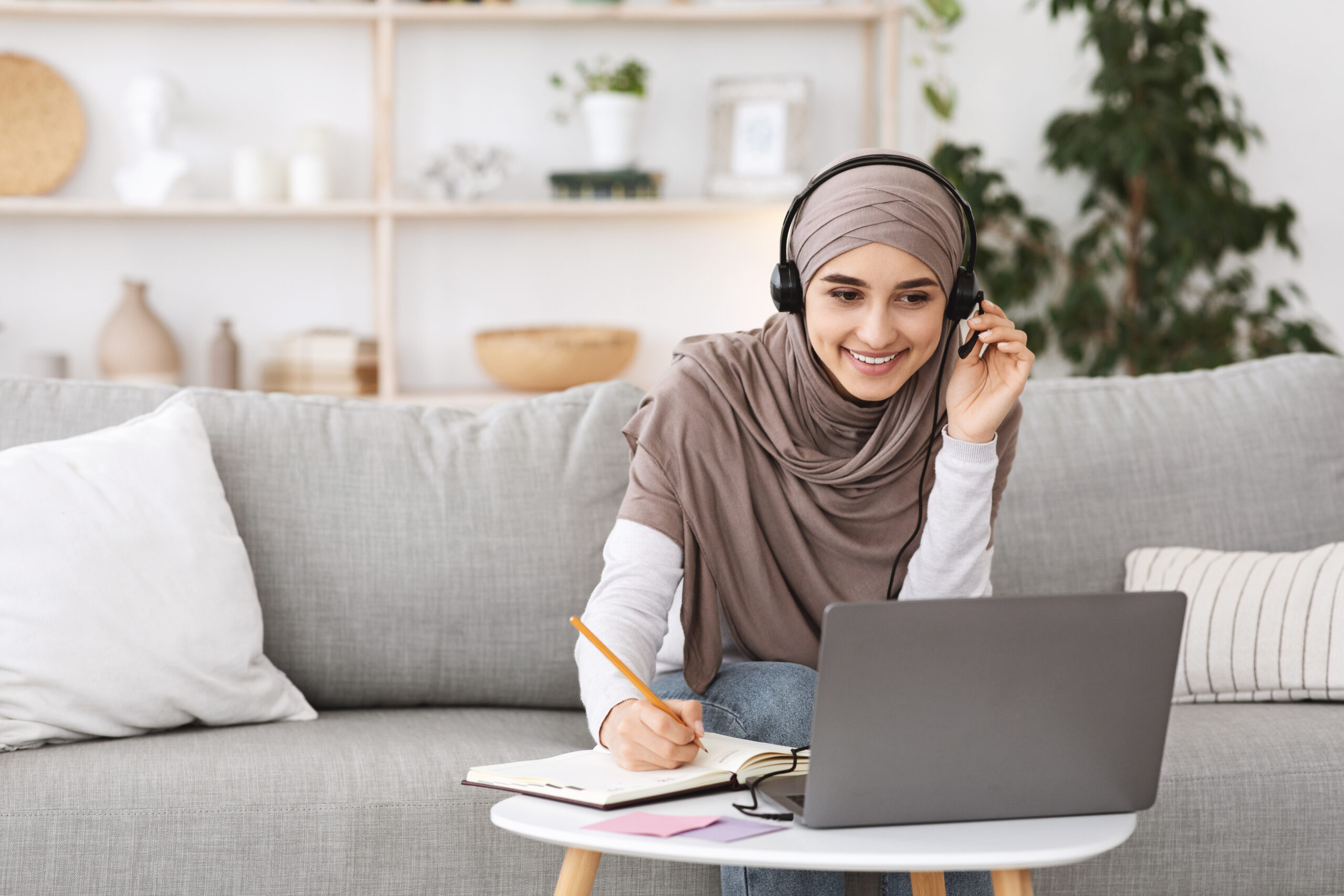 Girl taking notes with headphones on